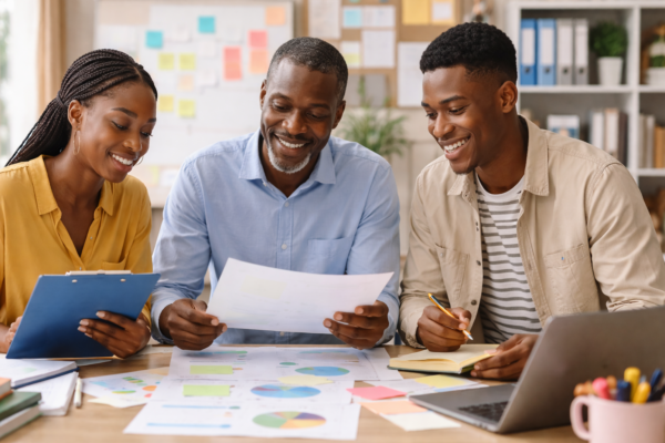 Educators collaborating on curriculum planning using charts, lesson frameworks, and digital tools in a modern classroom setting