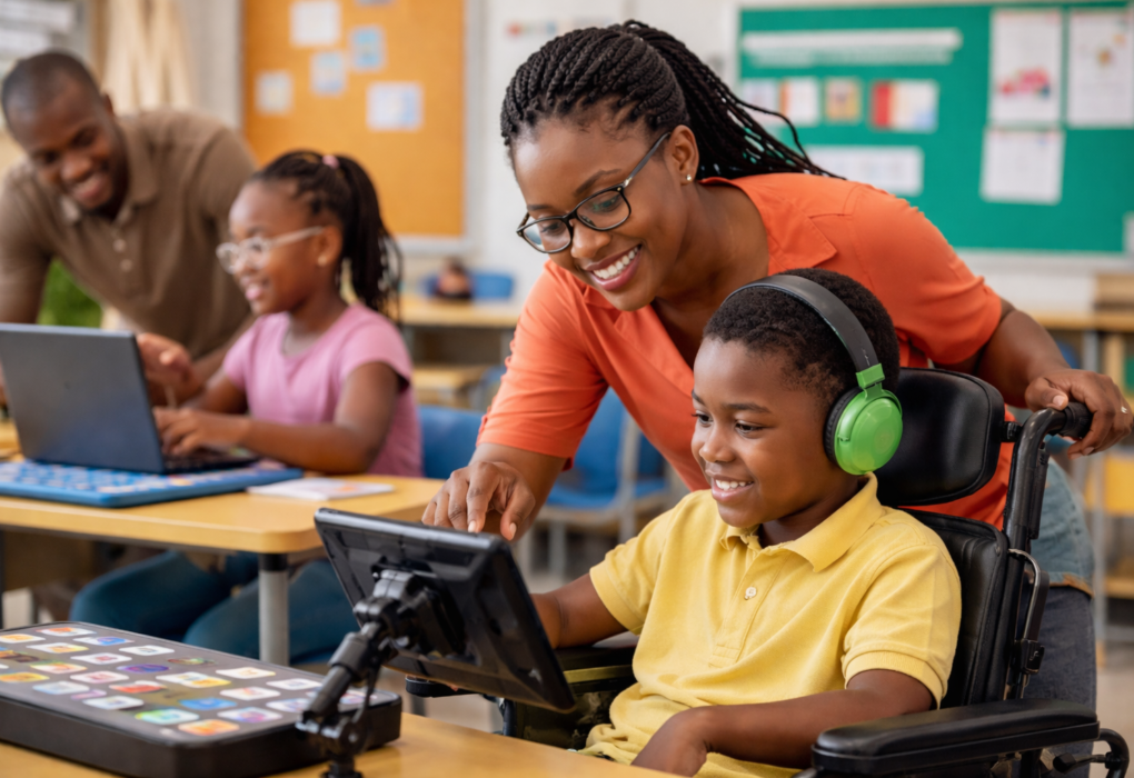 A diverse group of teachers collaborating in an inclusive classroom using assistive technology to support students with special educational needs