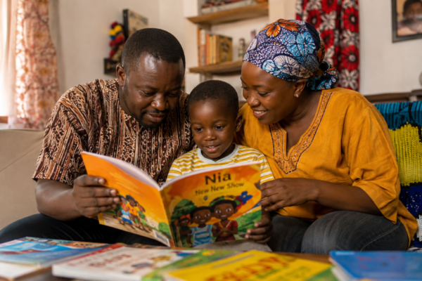 African parent reading a children's book with a young child at home